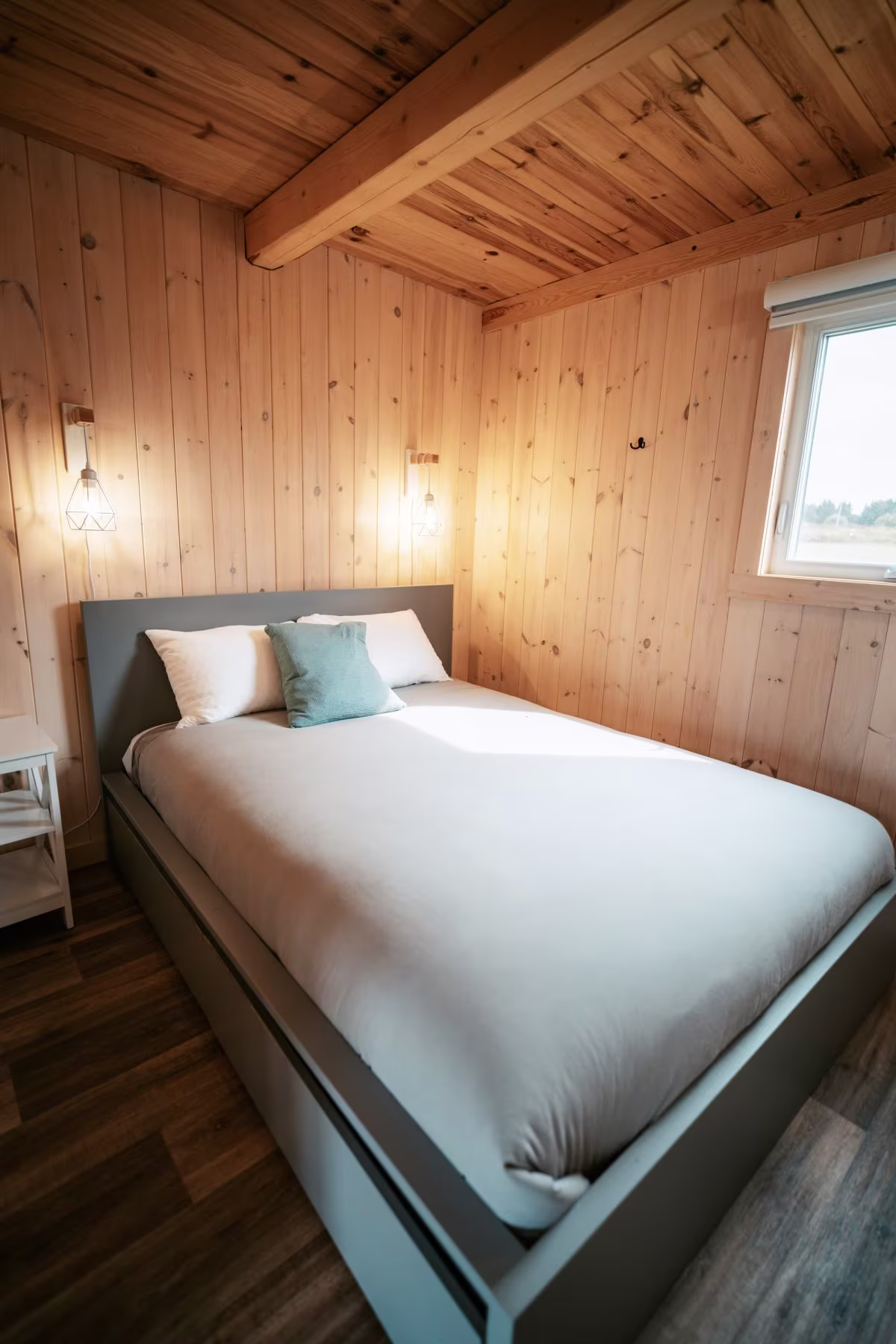 La chambre avec lit queen et murs de bois du chalet style suisse