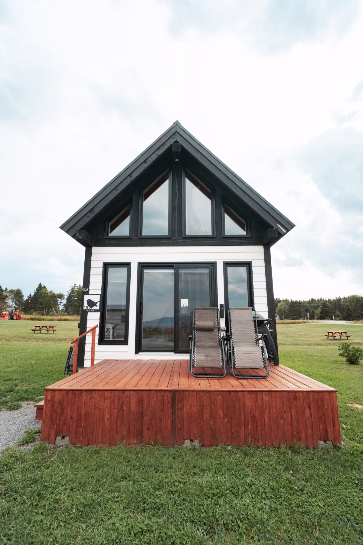 Le chalet à toit en pignon, façade vitrée et terrasse de bois du chalet style suisse