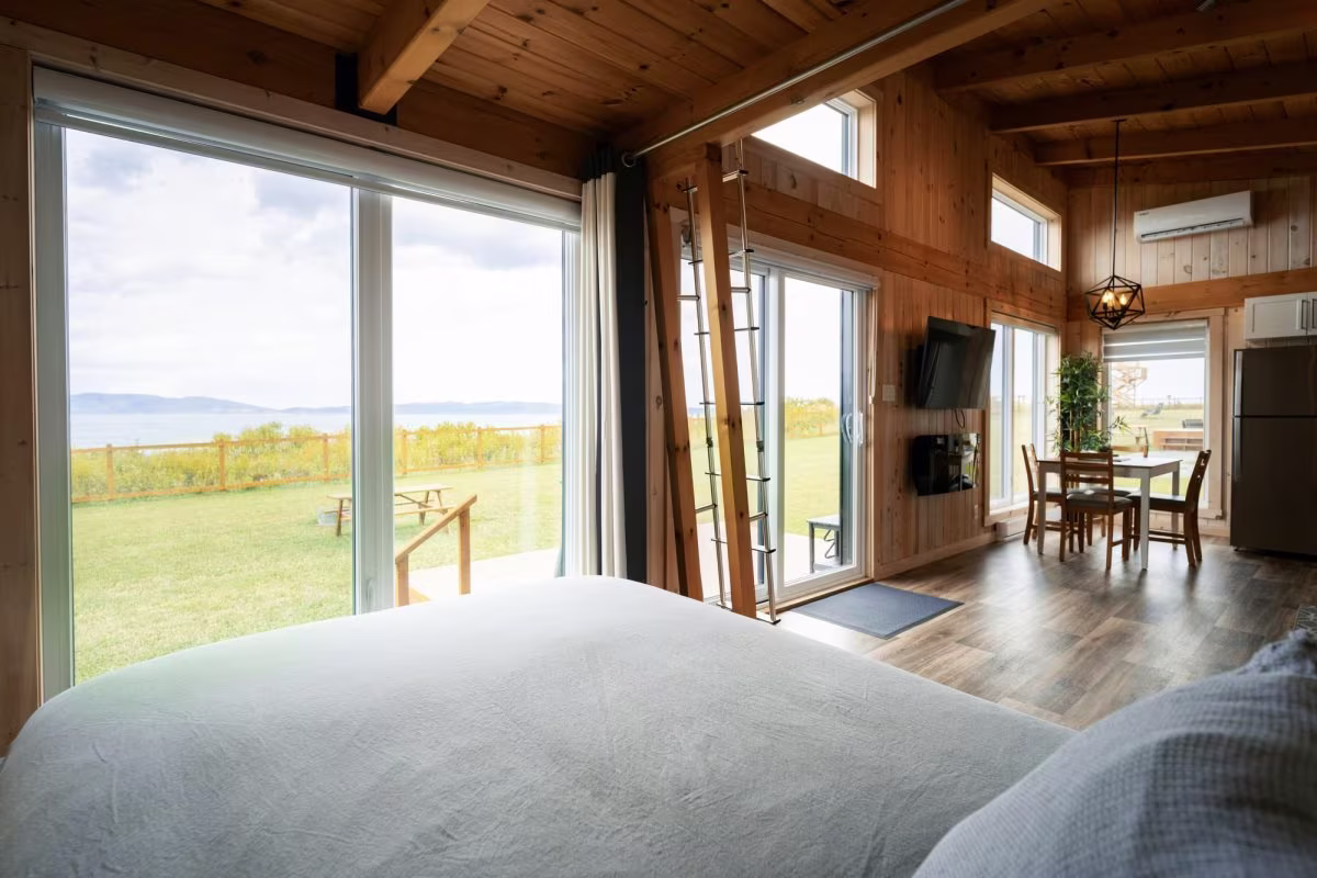 Das Schlafzimmer mit Queensize-Bett und großen Fenstern mit Meerblick im vorderen Teil des Chalets