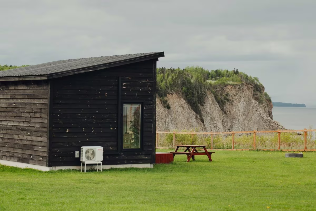 Das Chalet am Rand der Klippe, das Meer und die Küste im Hintergrund des Chalet im Vordergrund