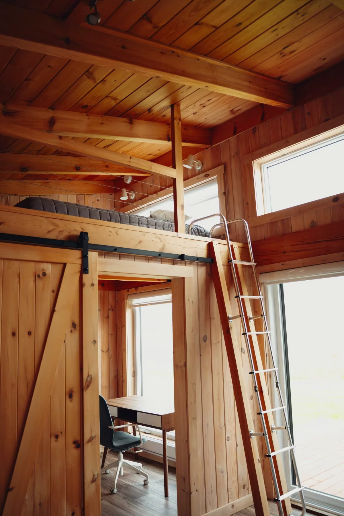 La mezzanine accessible par échelle, avec son coin bureau du chalet double avant