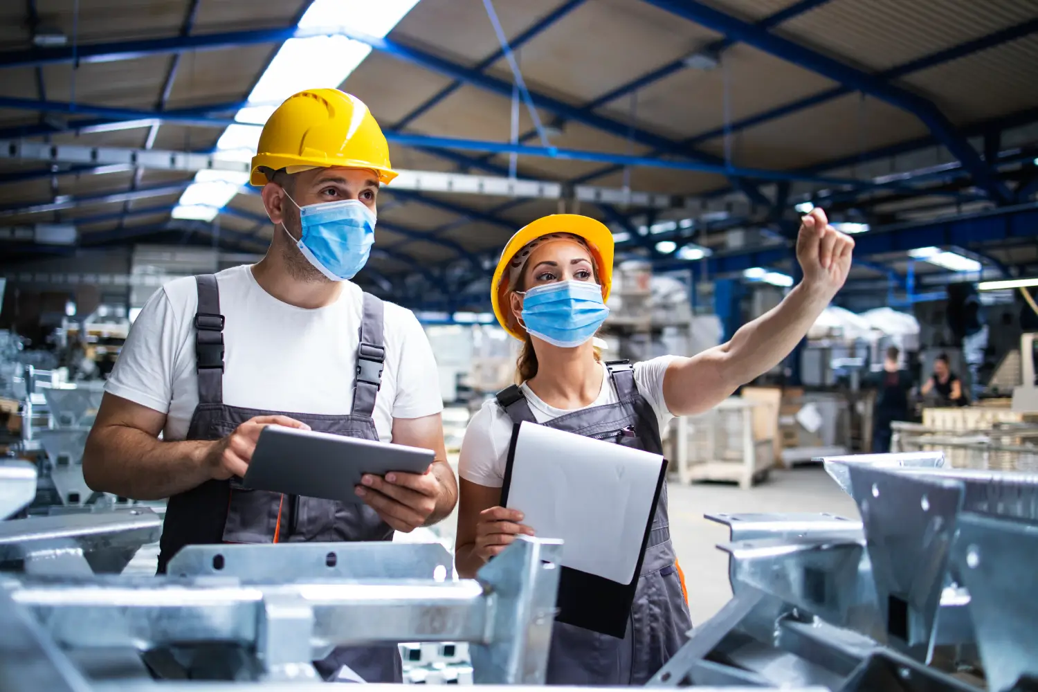 Factory workers using a tablet on the production floor