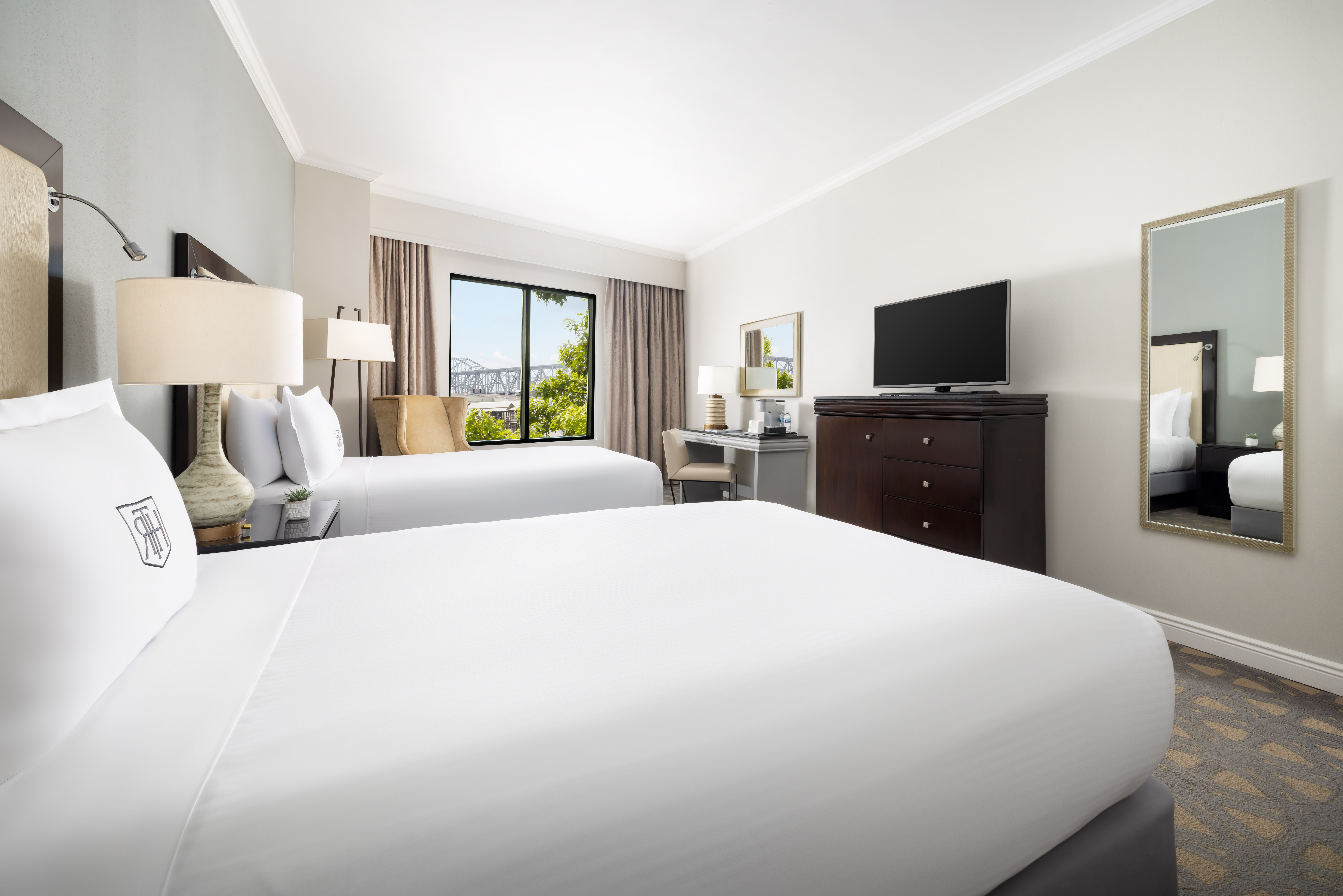Deluxe Two Double Beds with tv, desk and window view of bridge