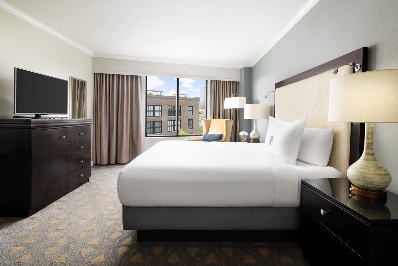 Deluxe King bedroom with tv and window view of new orleans