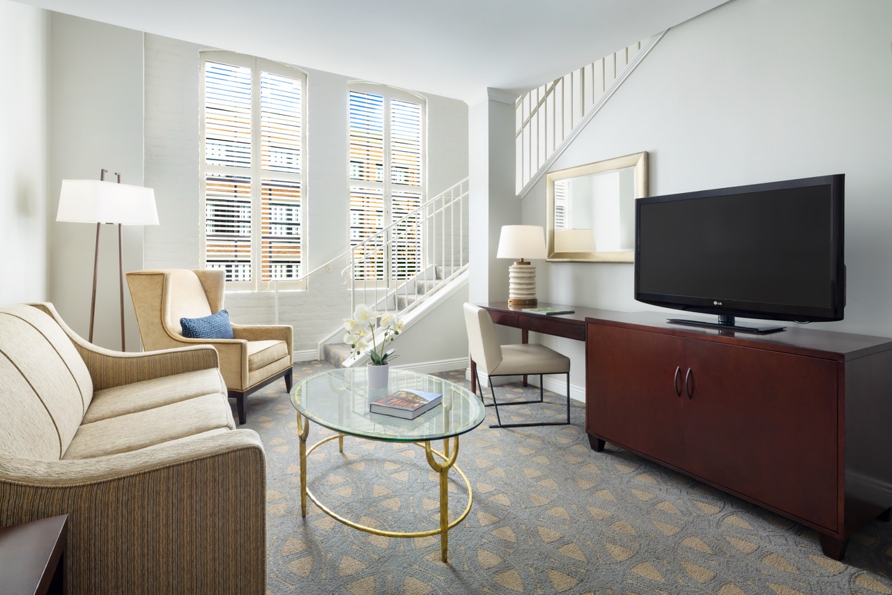 Executive Hospitality Loft Suite living room with tv and stairs to second level