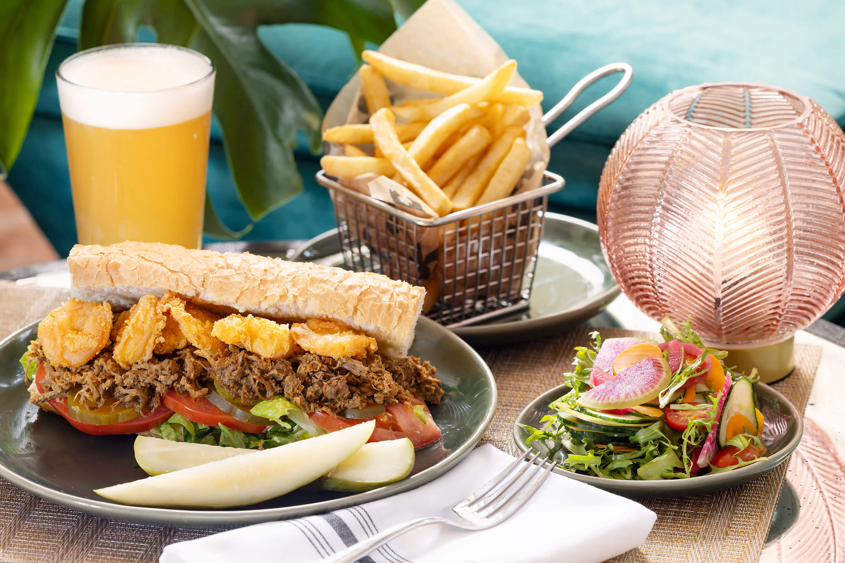 Sandwich, pickles and french fries on table with salad