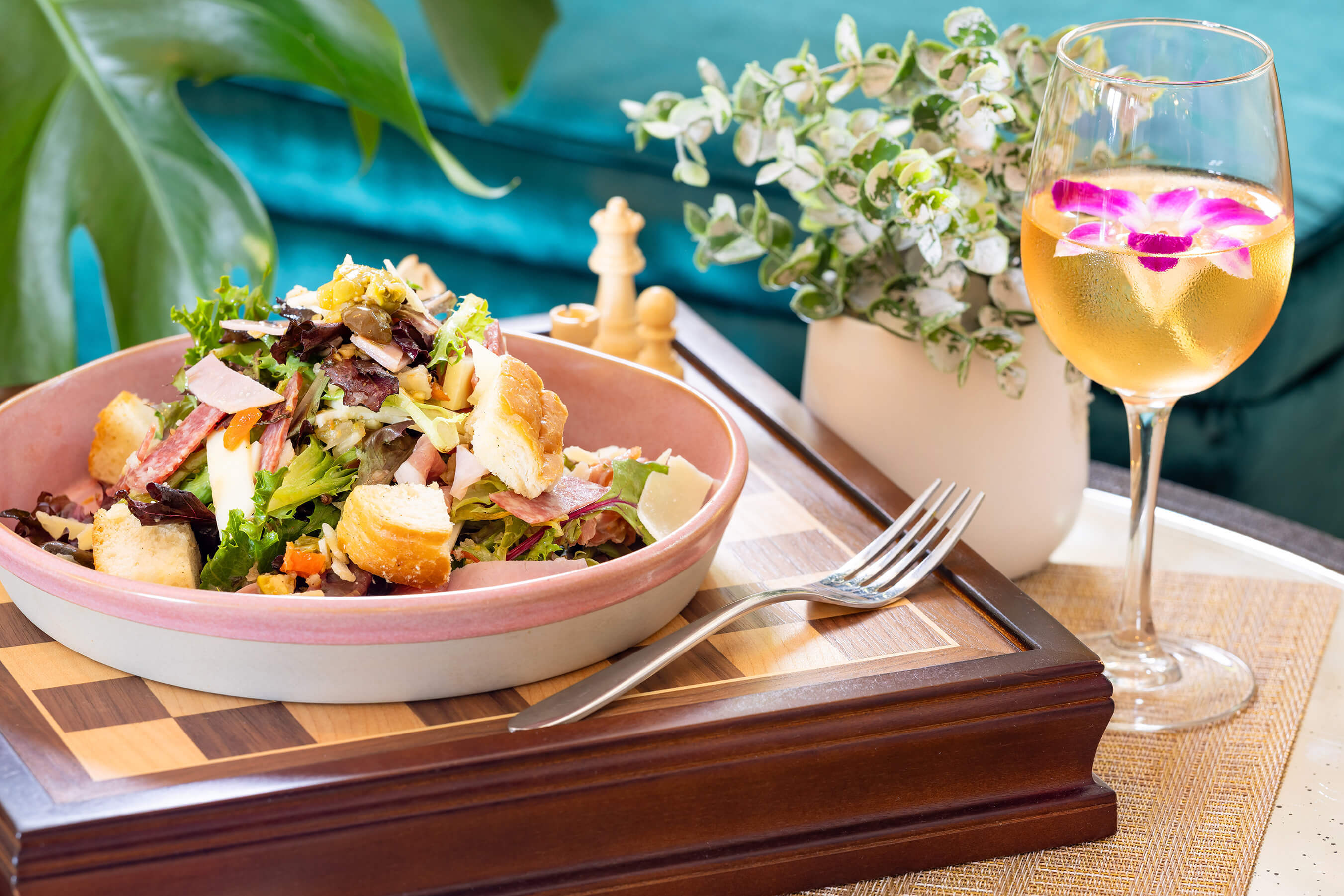 Delicious salad on chessboard with mixed drink