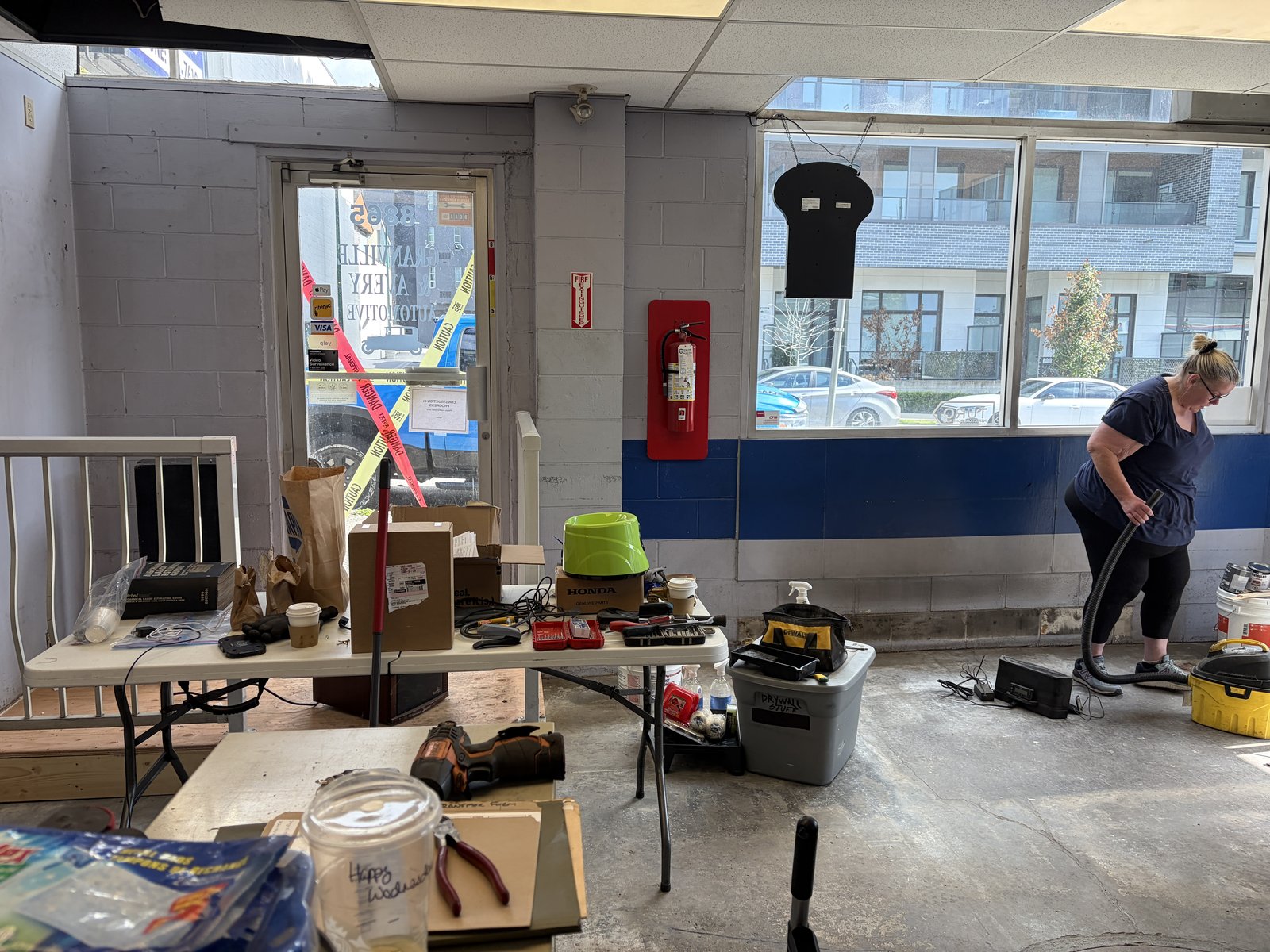 Old flooring removed and the bare front office floor being vacuumed