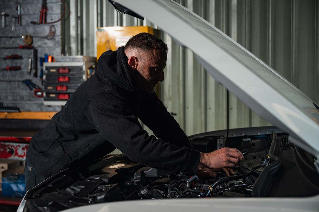 Mechanic inspecting vehicle engine during automotive servicing at Modbury Motors