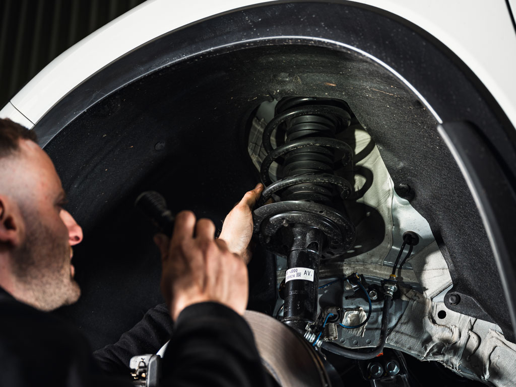 Mechanic inspecting vehicle suspension at Modbury Motors