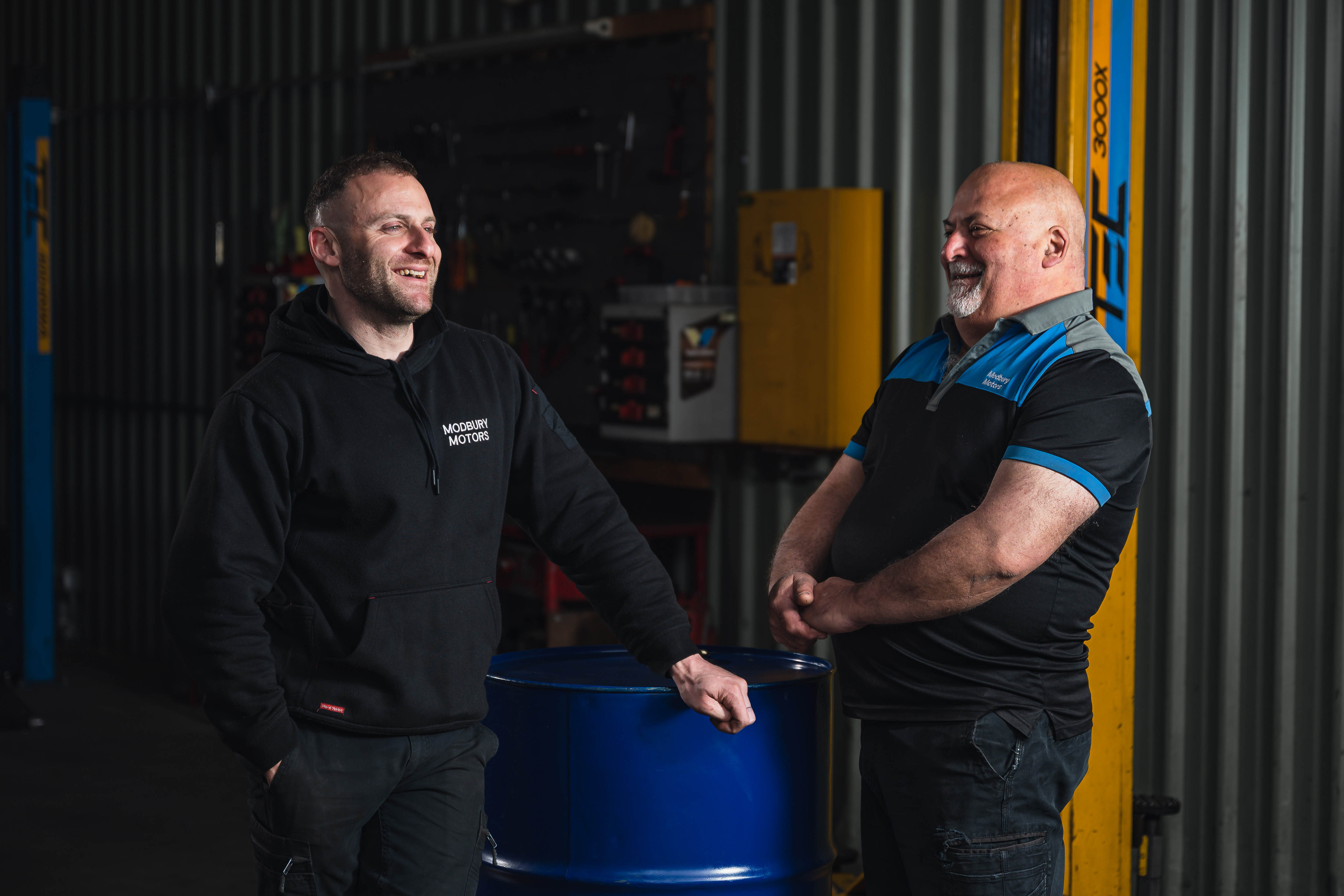 Chris Rinaldi and John Rinaldi discussing vehicle servicing at Modbury Motors workshop