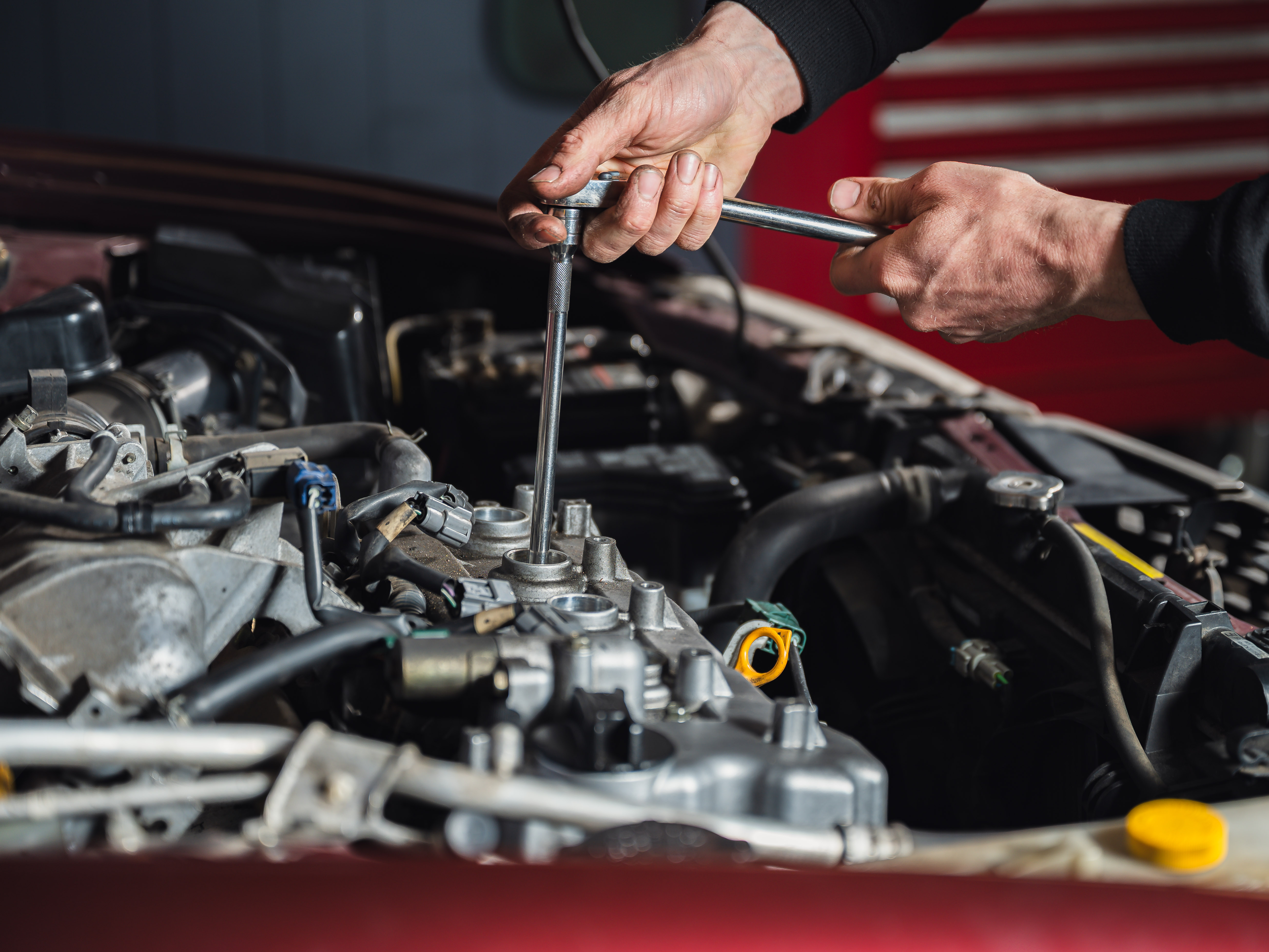 Mechanic in Modbury Motors is checking the spark plugs for a vehicle during an automotive service