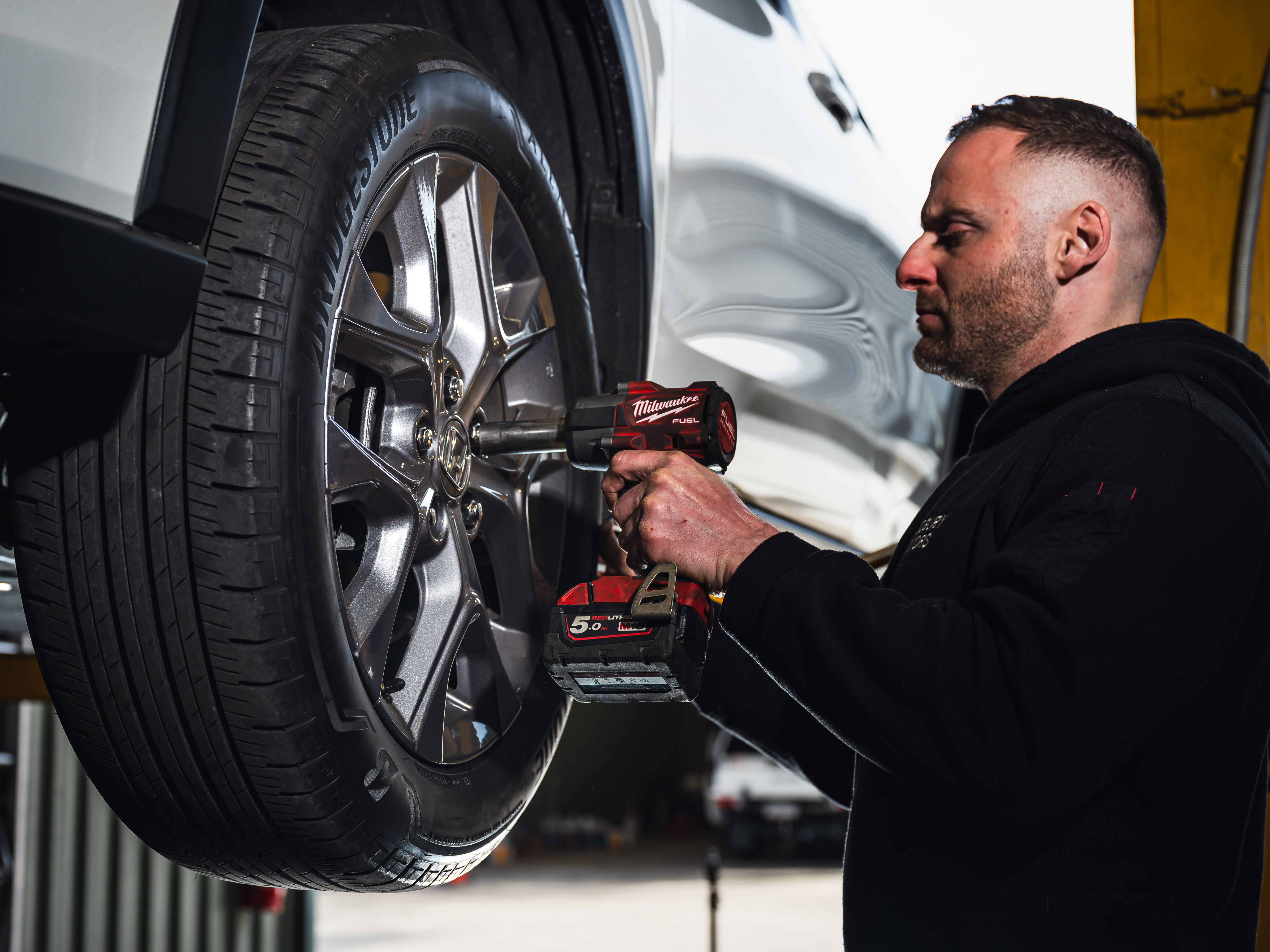 Mechanic in Modbury is taking the wheel off the car to inspect the brakes and suspension components