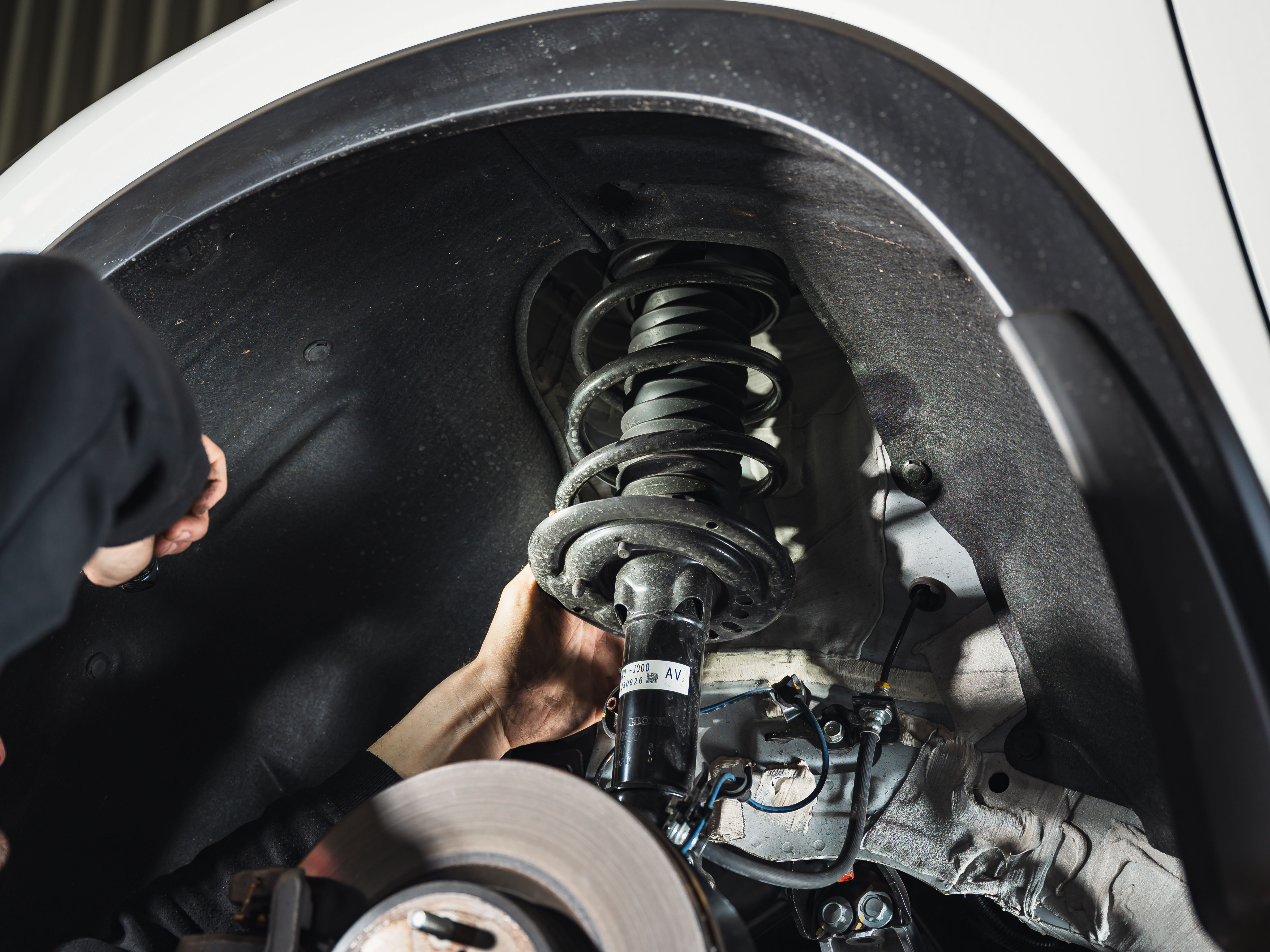 A mechanic is assessing suspension on a vehicle in Modbury to make sure they're in working order and not leaking.