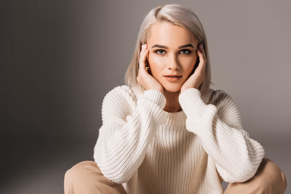 Editorial portrait of a woman with her hands resting beside her face