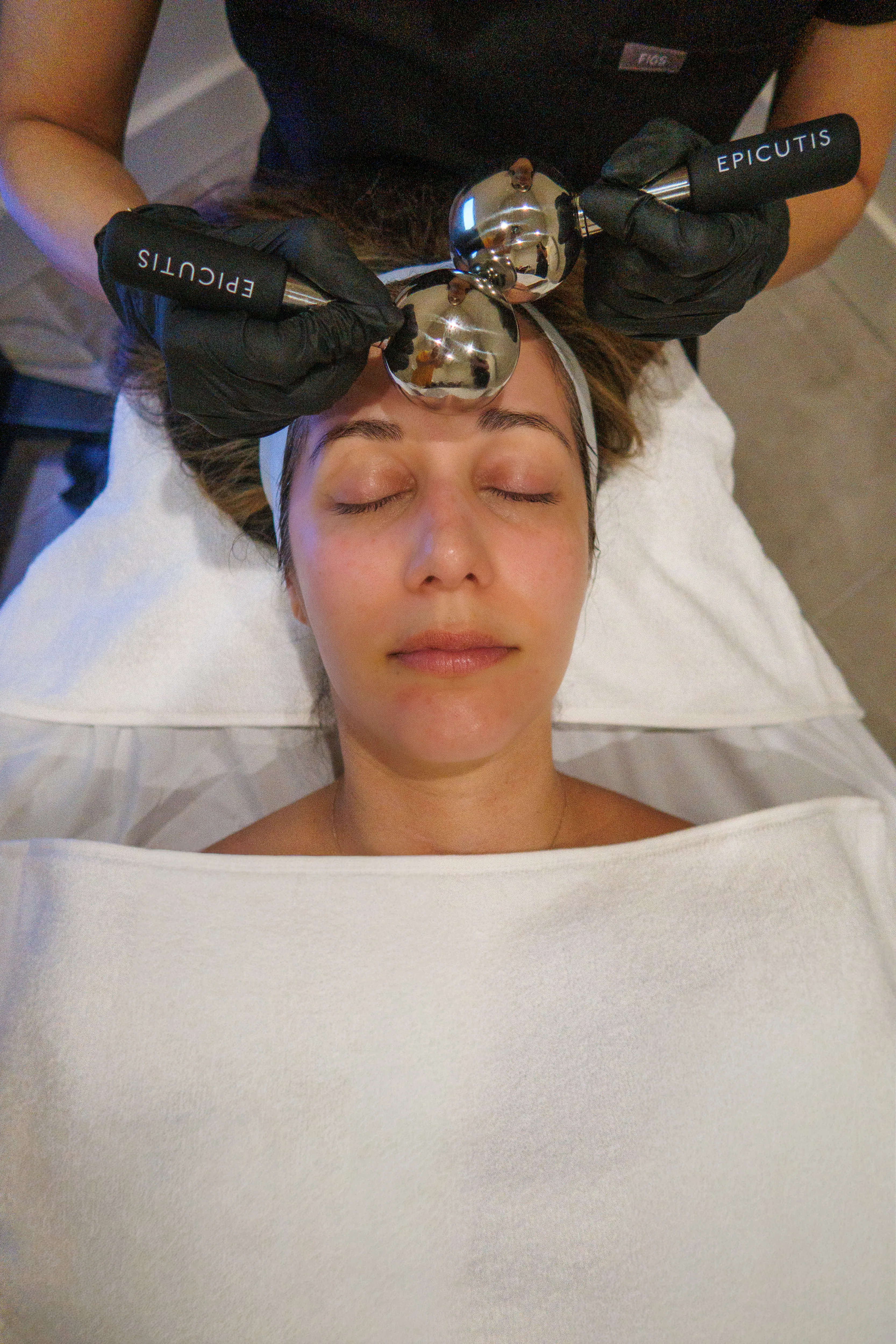Belle Vie provider using facial massage globes during a facial visit