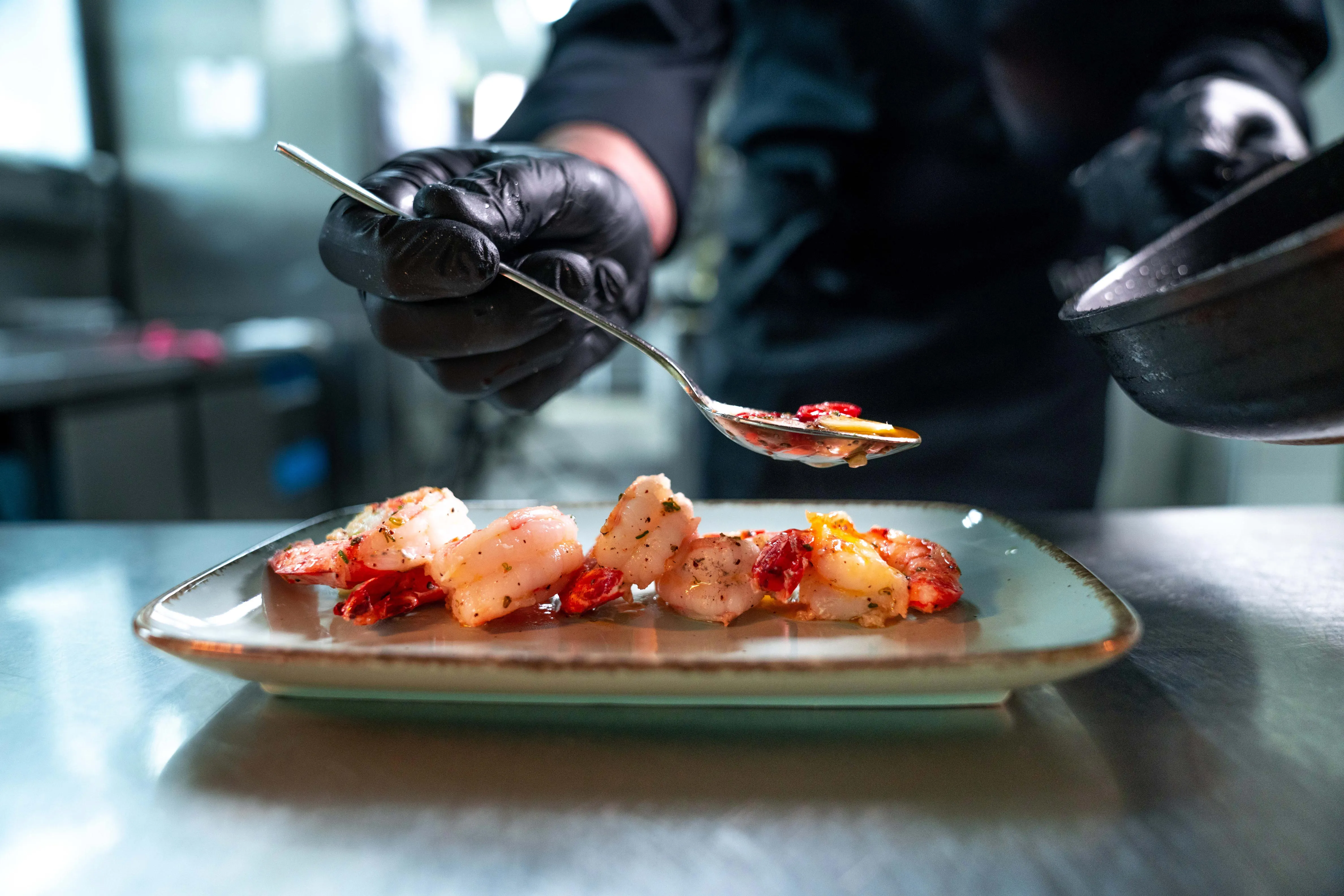 Koch gießt Soße über ein Gericht