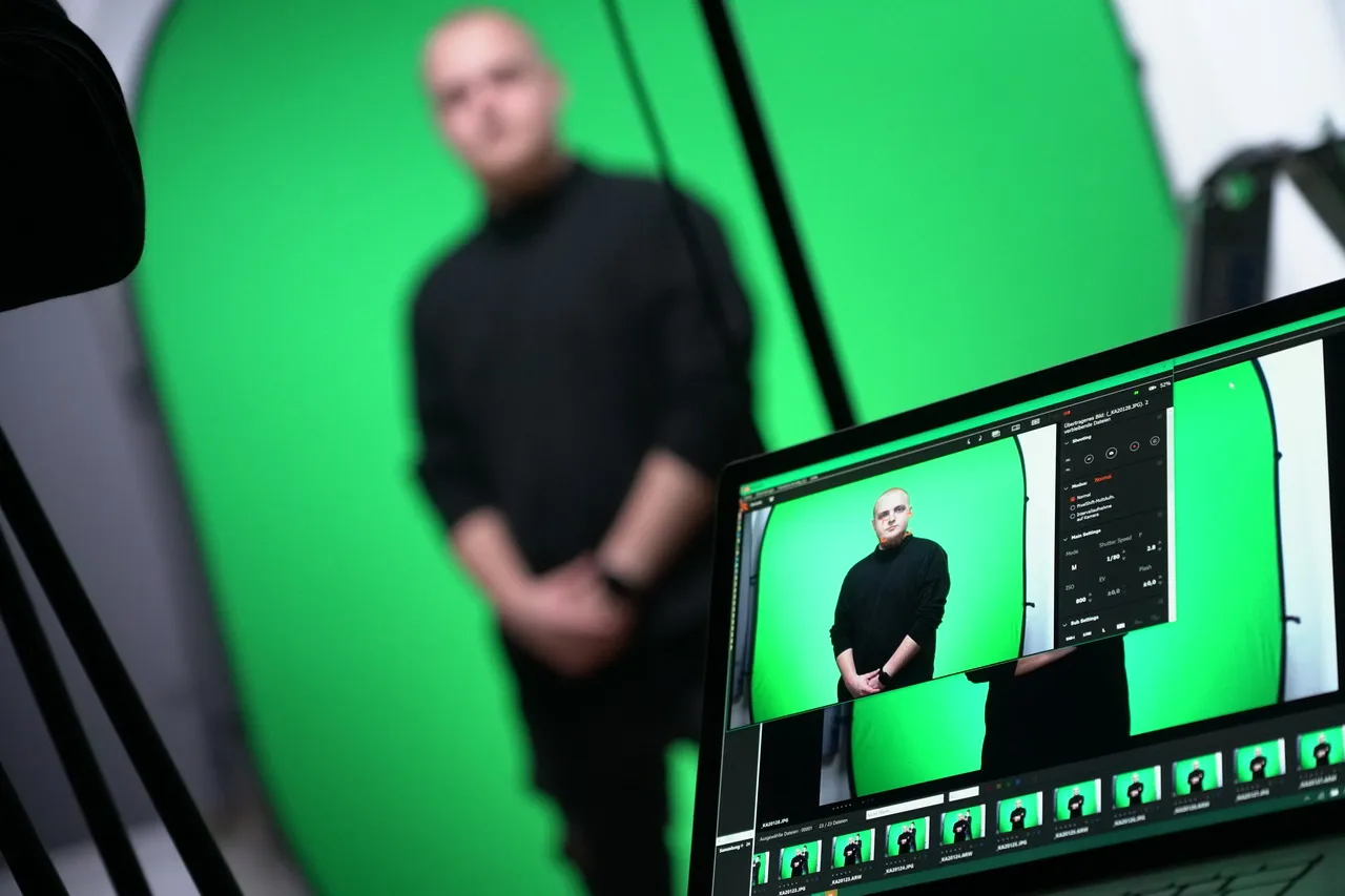 Mitarbeiter wird vor einem Greenscreen fotografiert