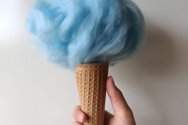 A Person Holding Cone Filled With Candy Floss