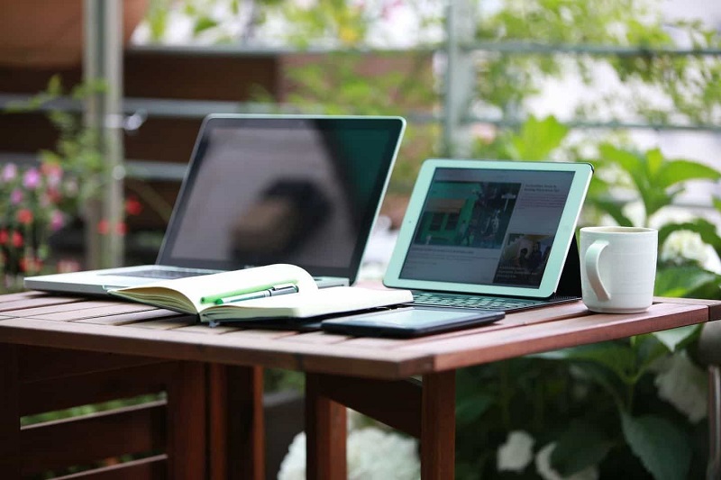 A laptop and a tablet is placed on the table.
