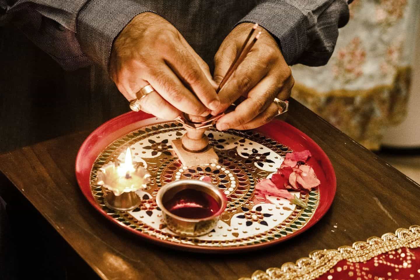 A Man is Arranging Incense Stick in Decorative Pooja Thali