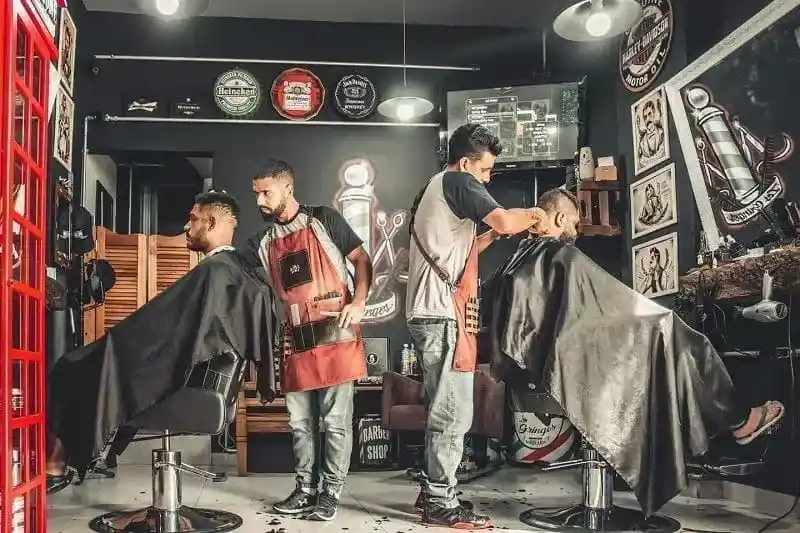 Two boys are cutting hair in salon.
