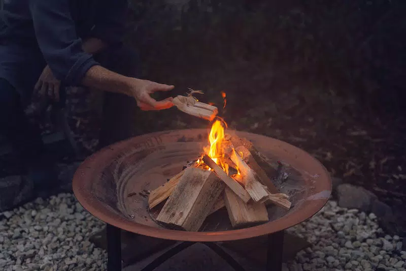 A girl bruning the wood on the fire