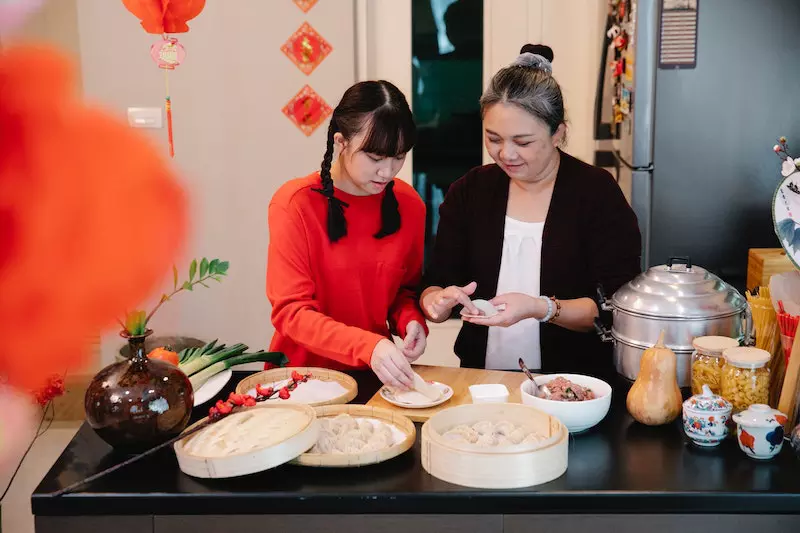 Two ladies are making momos in their kitchen
