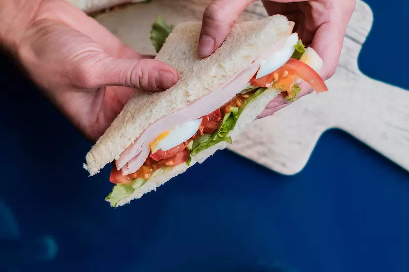 A girl is taking sandwich 