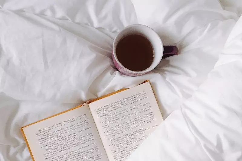 A cup of tea and book is displayed on the screen