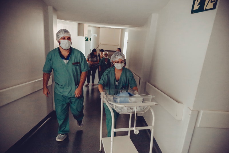 Hospital staff carrying trolley.