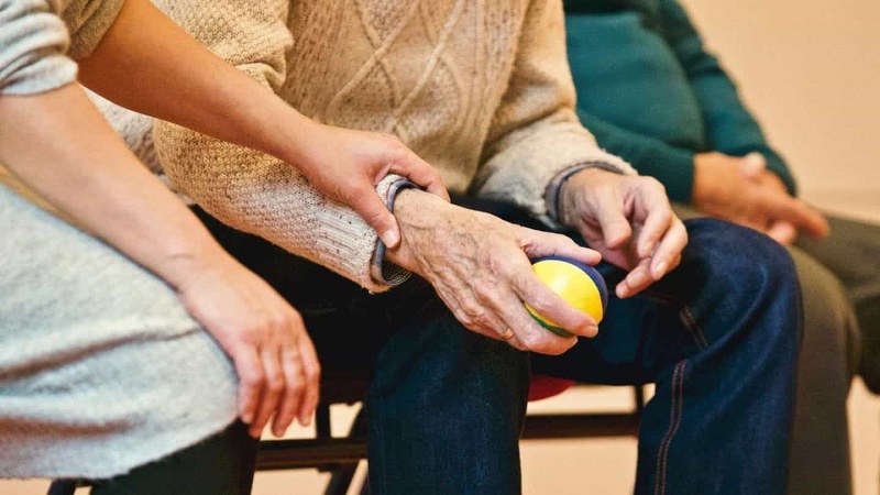 Old man is shown a ball holding in his hand