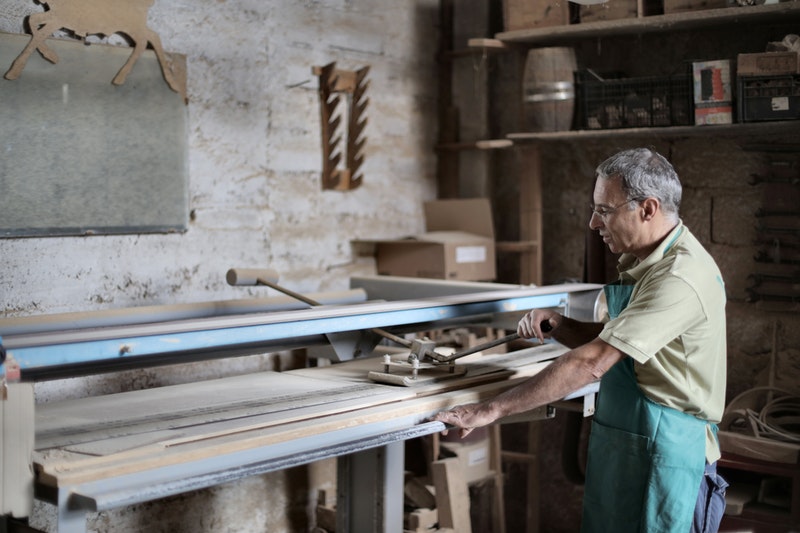 A old man working on lathe machine.