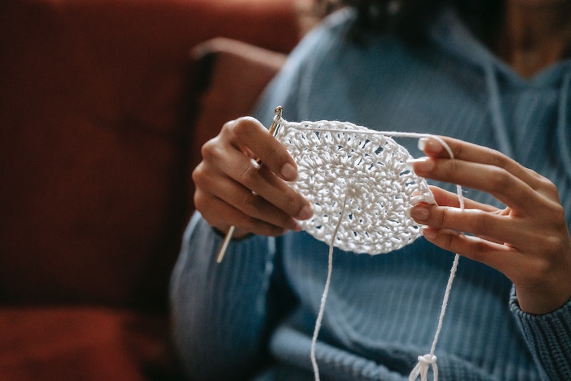 Lady is making something with a wool