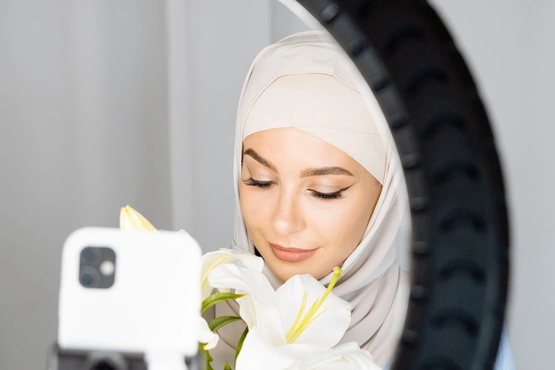A Lady is making video for her channel in front of the ring light