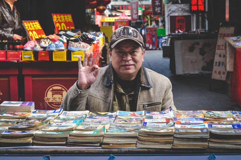 A man selling books and stationery items.