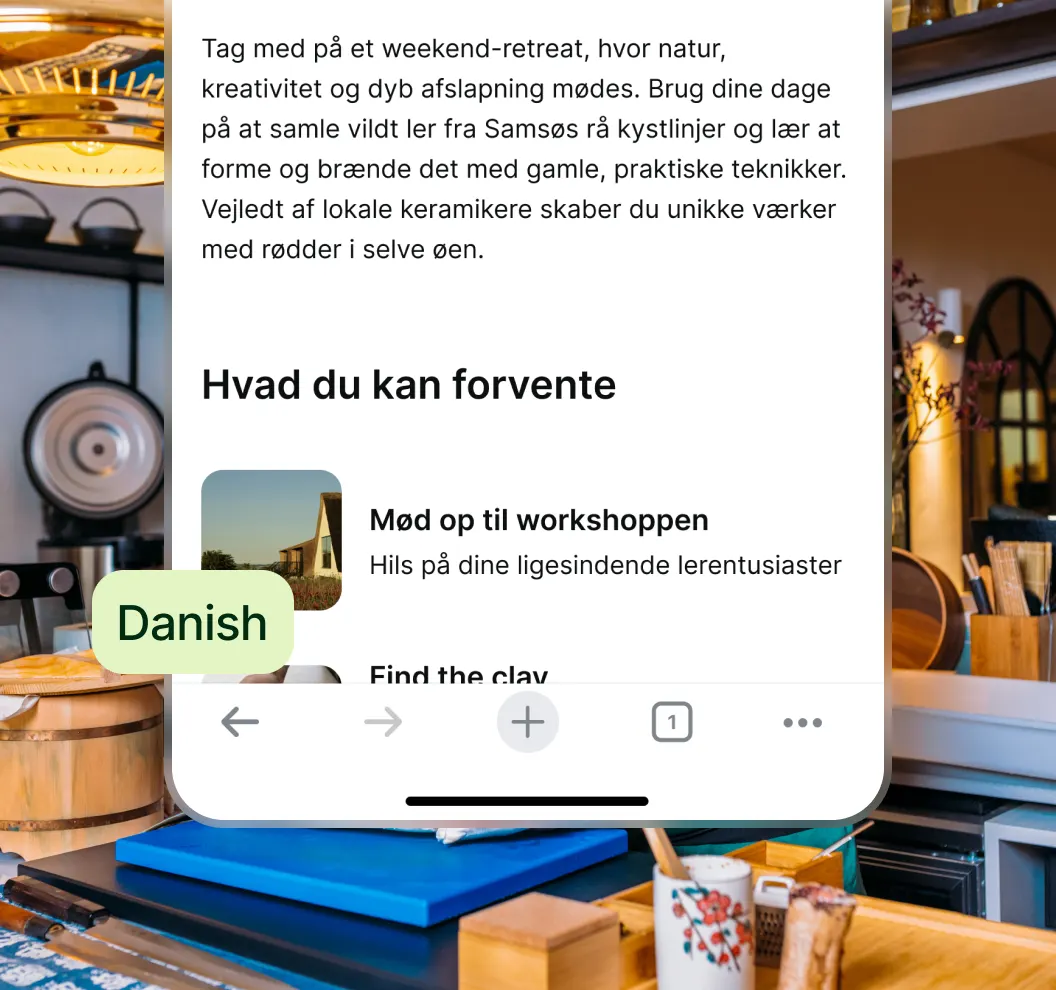 Mobile screen showing Danish text about a weekend retreat with nature, creativity, and clay workshops, overlaid on a cozy kitchen scene.