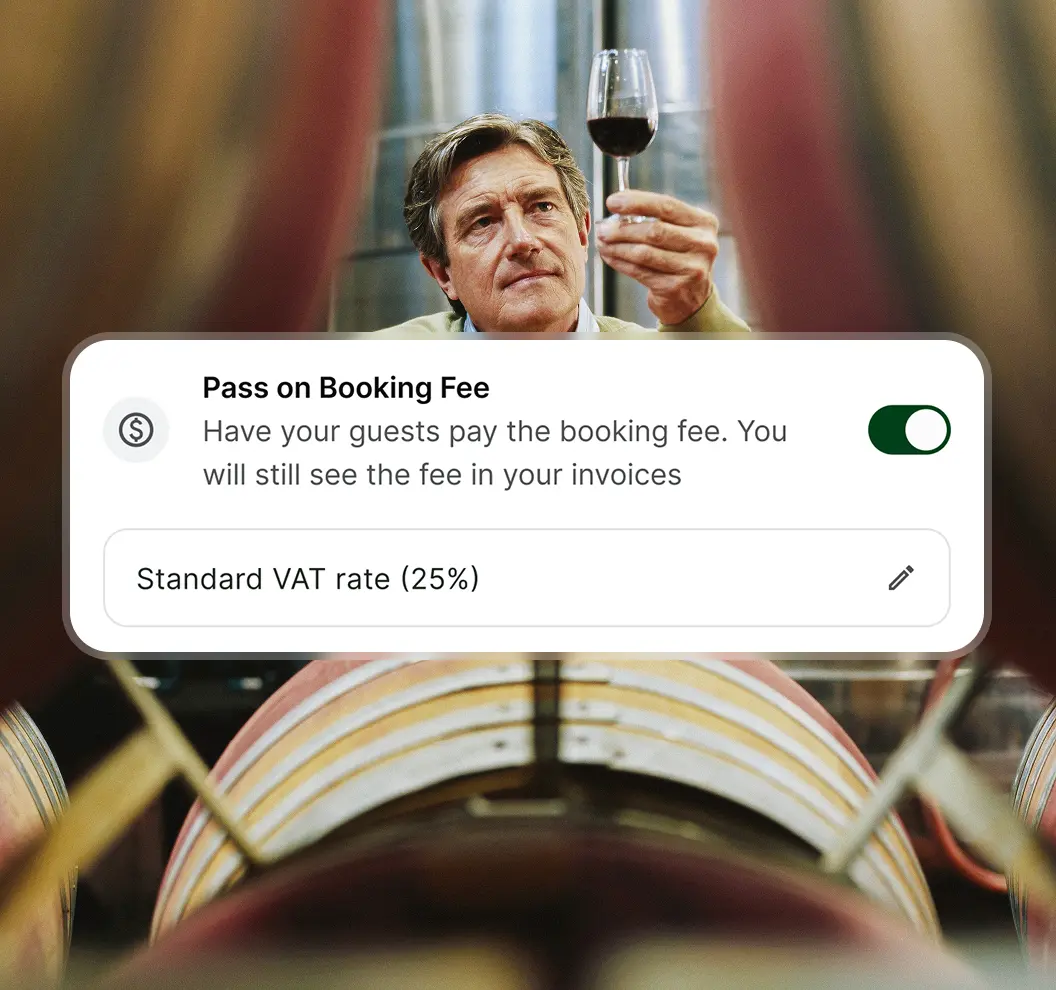 Man inspecting a glass of red wine in a cellar with barrels, with overlay text about passing booking fees and VAT rate.
