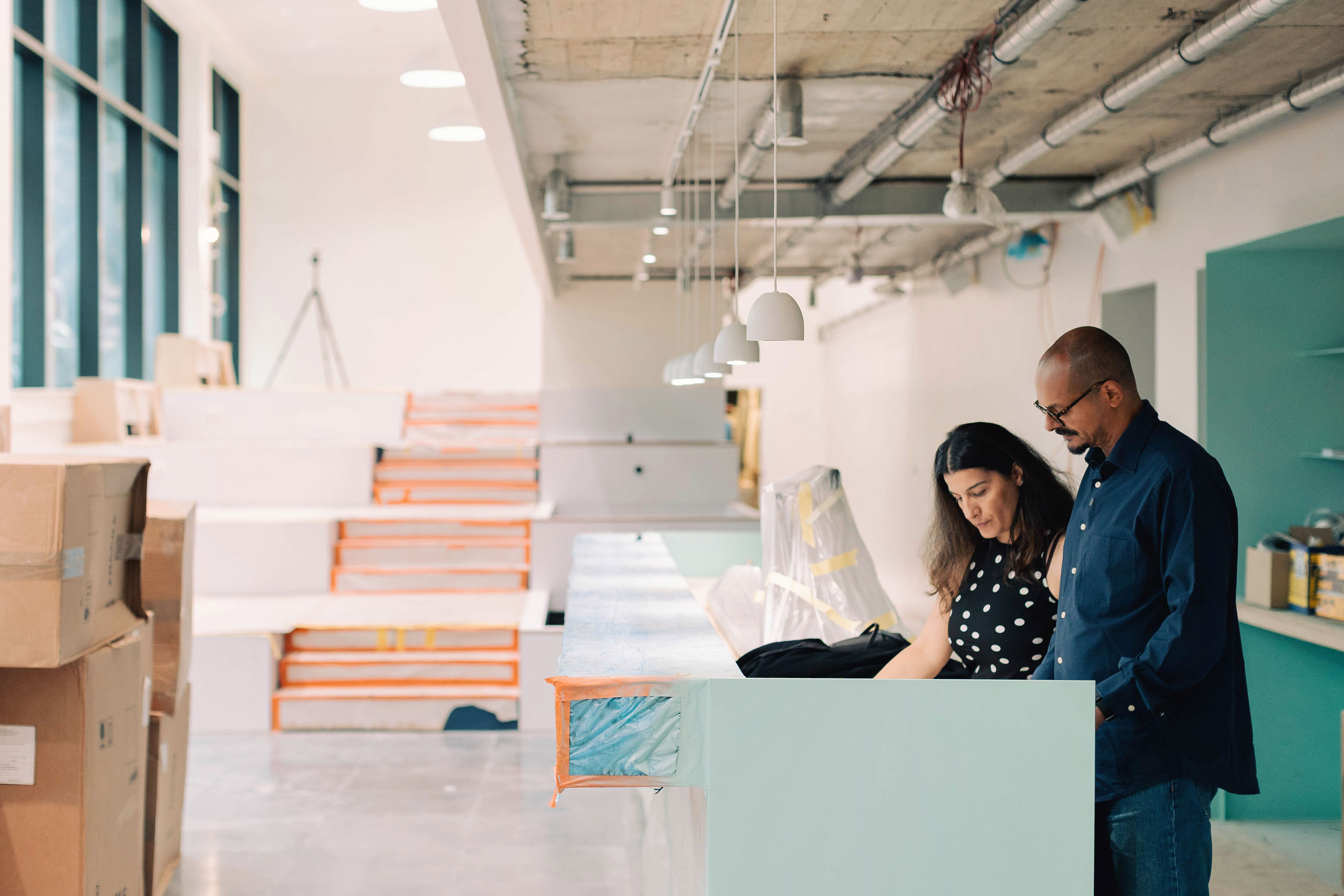 Vue d'ensemble du chantier horeca avec estrades blanches et consultation de plans — EcoCasa-Construct
