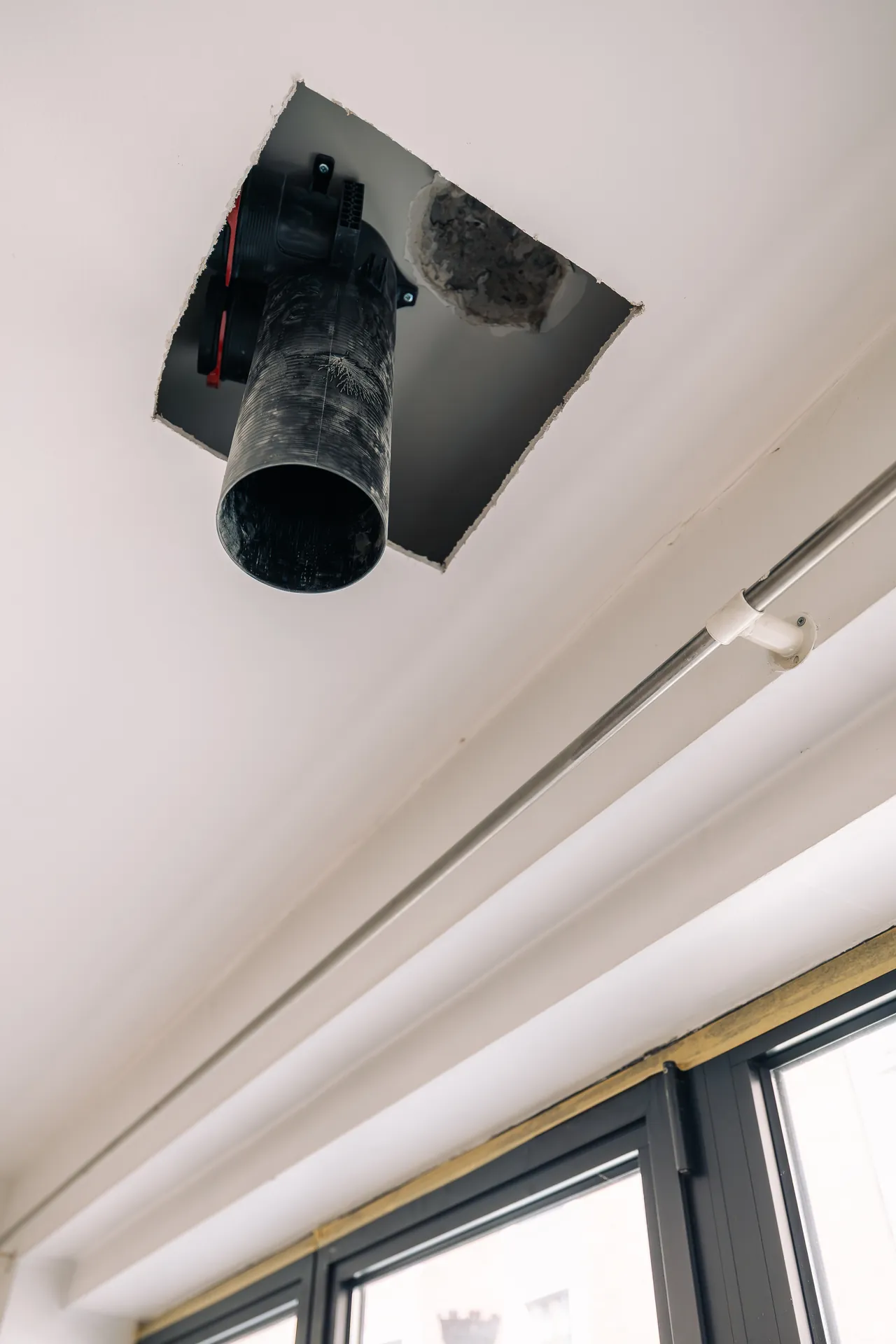 Piquage de gaine de ventilation au plafond — appartement rénové au centre de Bruxelles