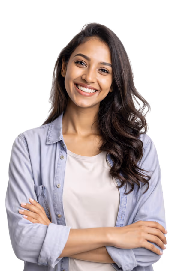 Smiling young woman with long dark wavy hair, wearing a light shirt and denim button-up, arms crossed.