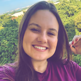 Fotografia de Mariane Renner, mulher sorridente de cabelo castanho ao ar livre