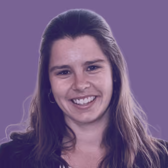 Smiling woman with long brown hair against a solid purple background.