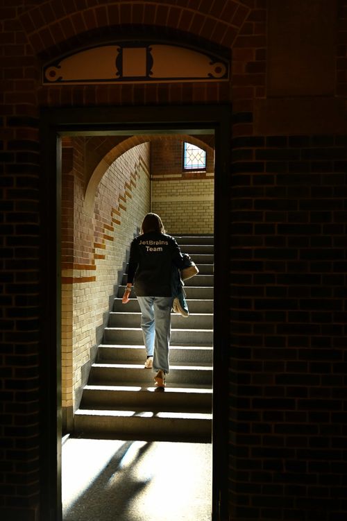 JetBrains team member walking up a sunlit staircase in a historic building