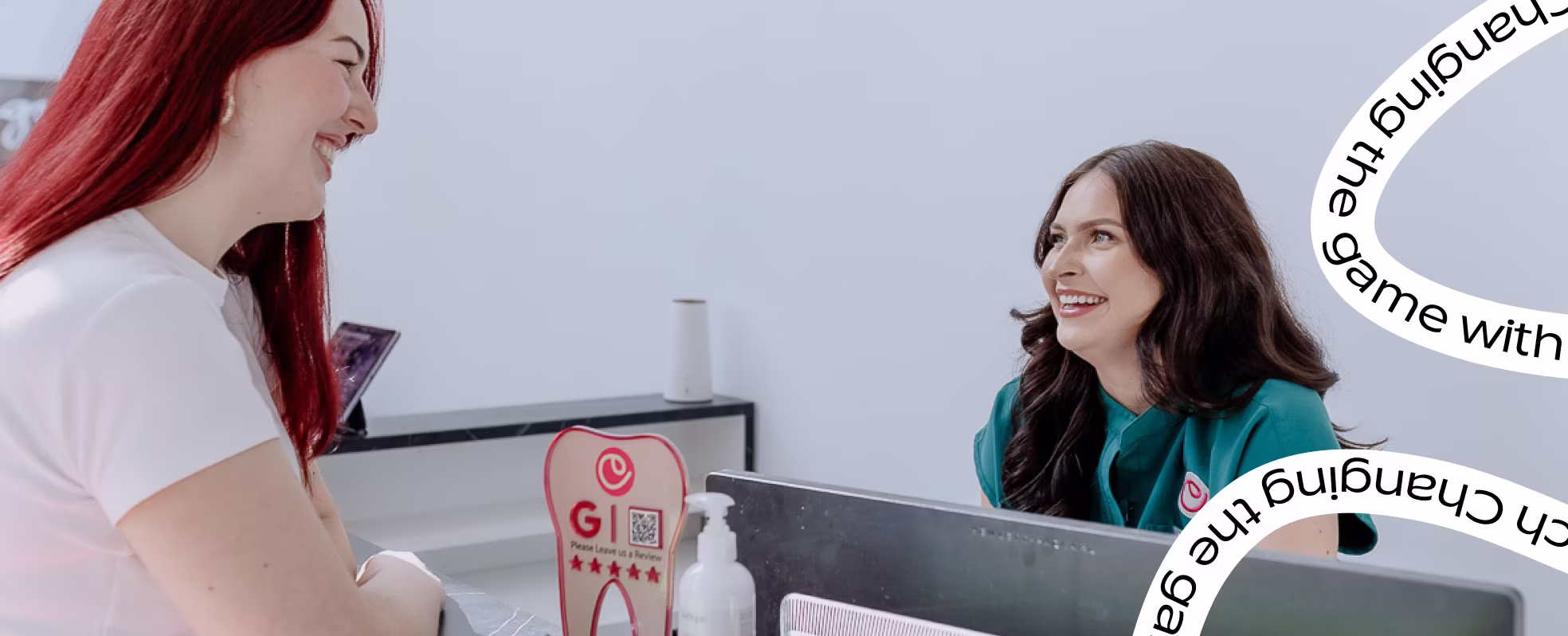 Patient chatting with a smiling team member at the reception desk at Cheeky The Dentist Waterloo