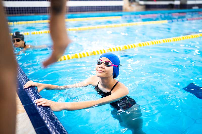 barn i en pool i en simhall