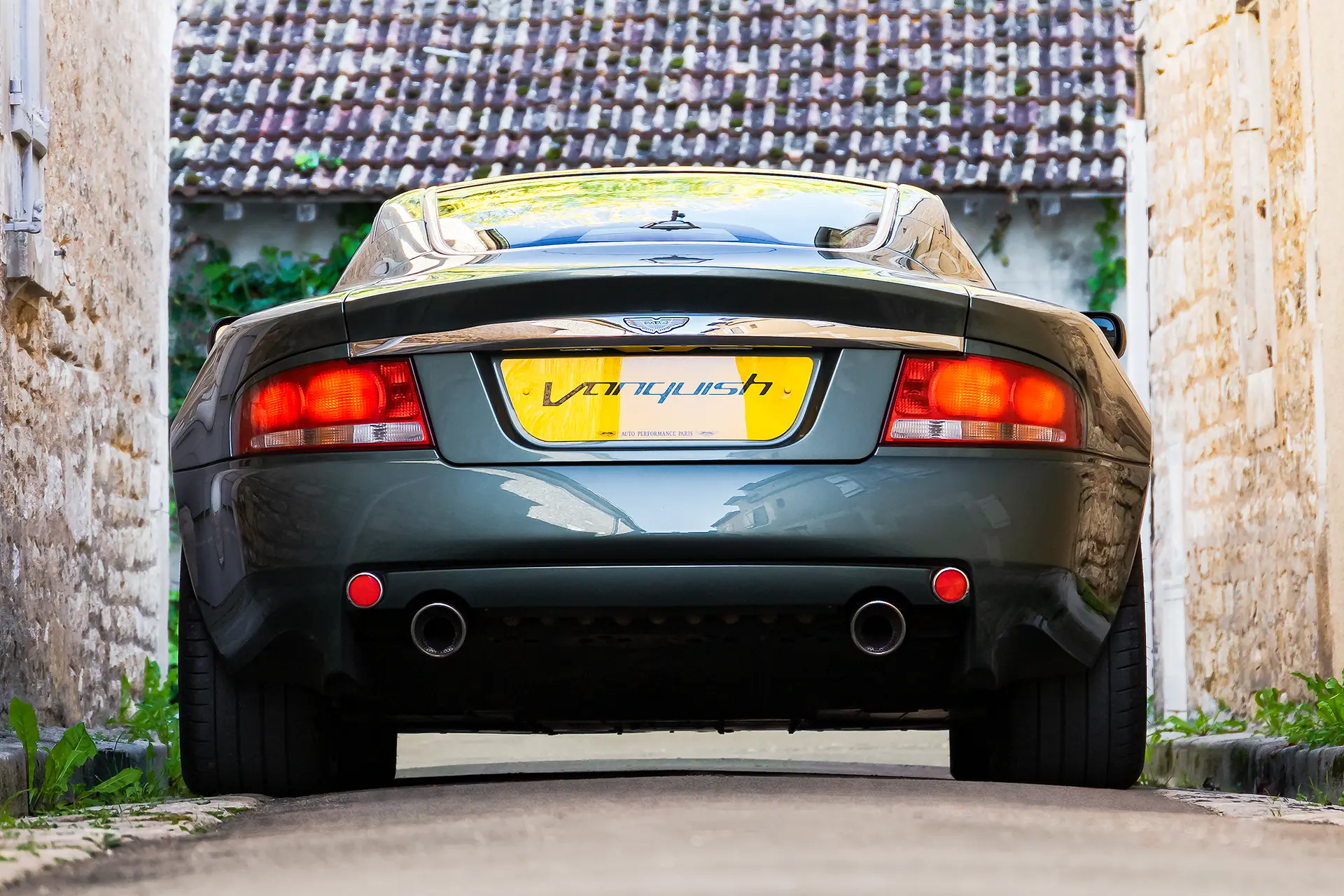 ArriÚre d'une Aston Martin Vanquish verte avec une plaque constructeur personnalisée