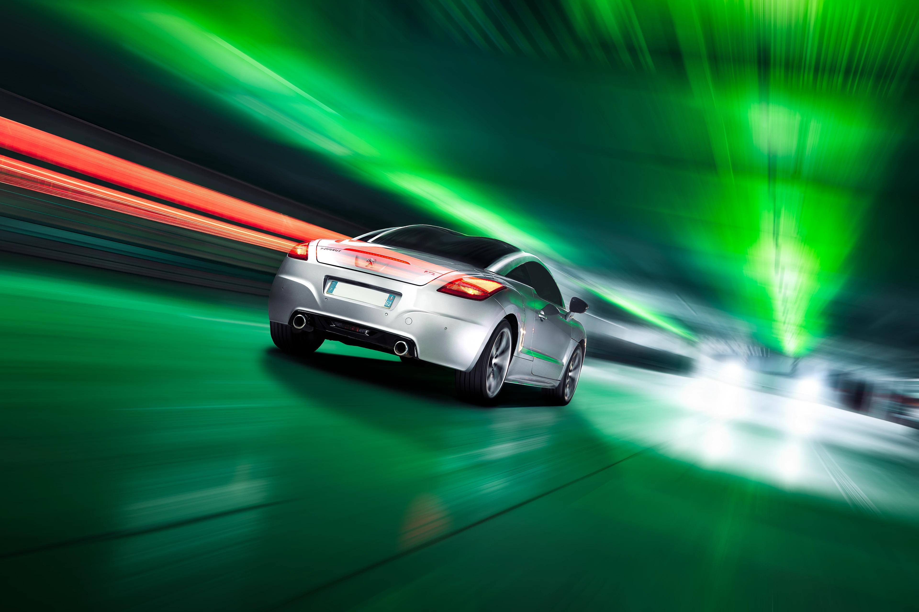 Peugeot RCZ grise de 3/4 arriĂšre roulant dans un parking sous-terrain Ă dominante verte