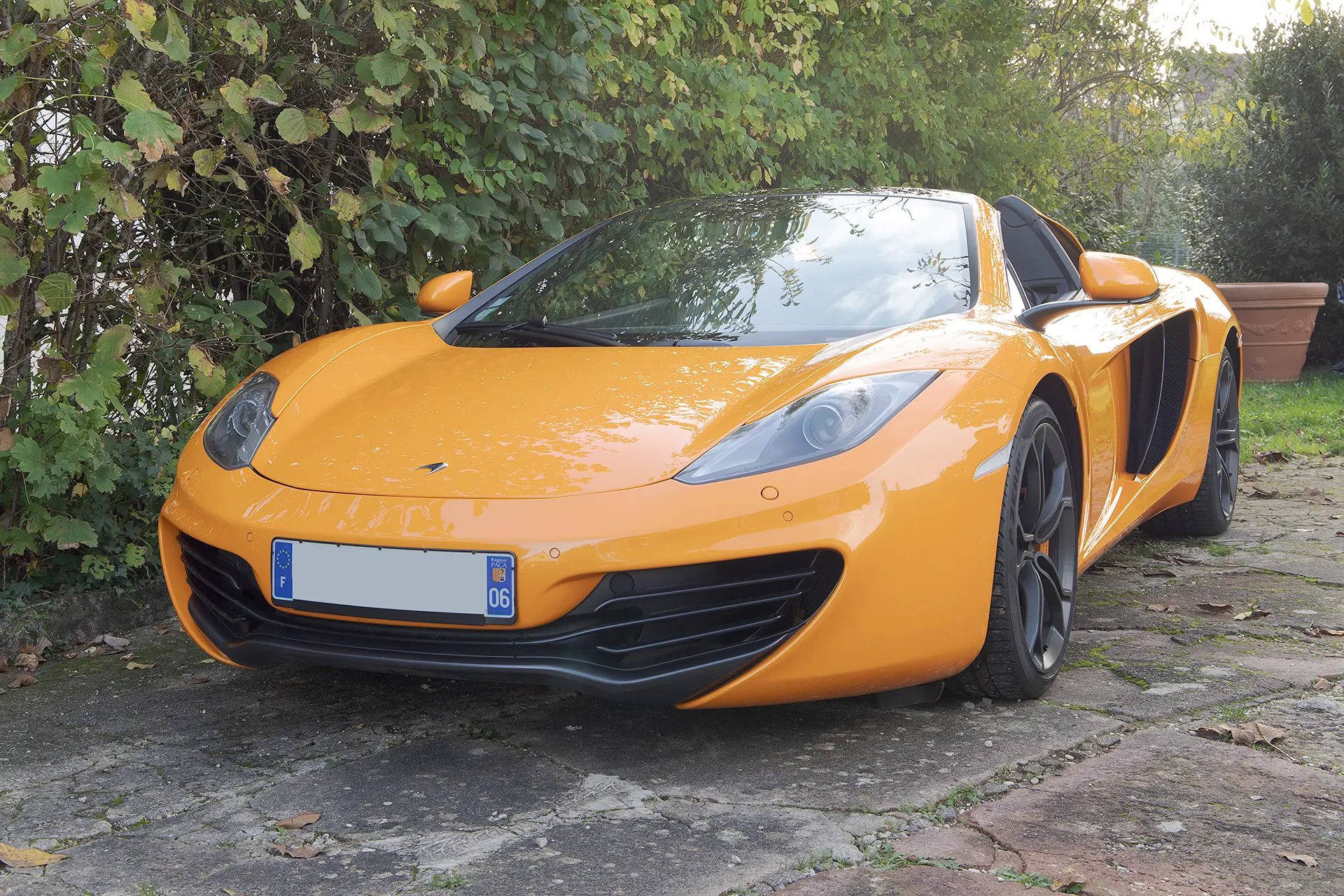 Photo brute non retouchée d'une McLaren MP4-12C orange papaye de 3/4 avant