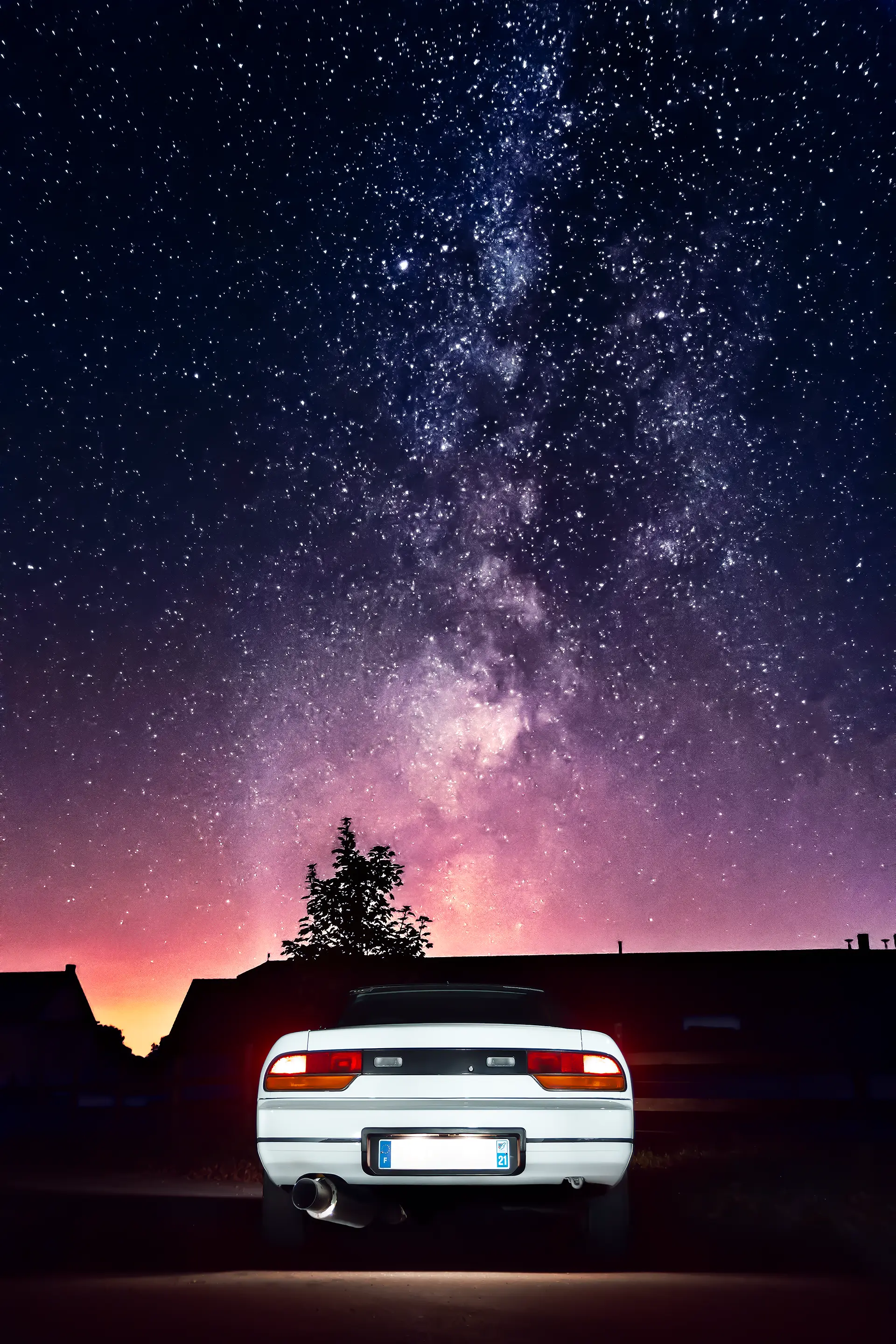 Arrière d'une Nissan 200SX RS13 blanche de nuit sous la voiture lactée en light painting